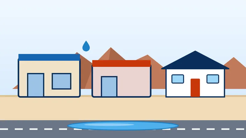 Small shops and a house on a city center street in downtown Apache Junction with a water leak